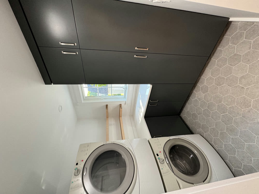 Laundry room with dark cabinetry